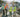 Three construction workers in hard hats standing on a construction site conducting land surveying safety procedures.