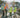 Three construction workers in hard hats standing on a construction site conducting land surveying safety procedures.