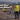 A surveyor standing on a work site with tripod and a letters asking whether RTK Service or Local Base Station is better. 